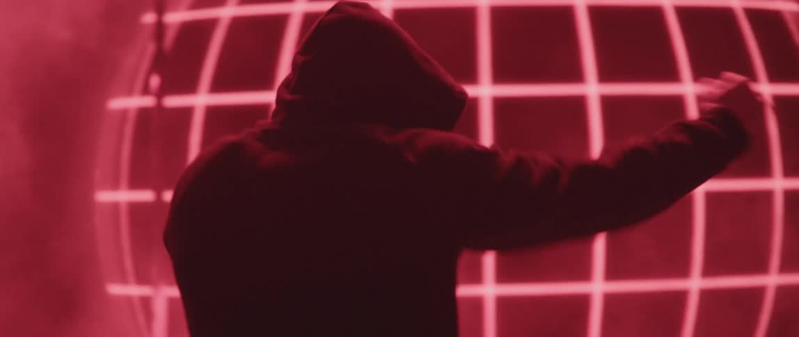 A man shadow boxes in front of a display screen