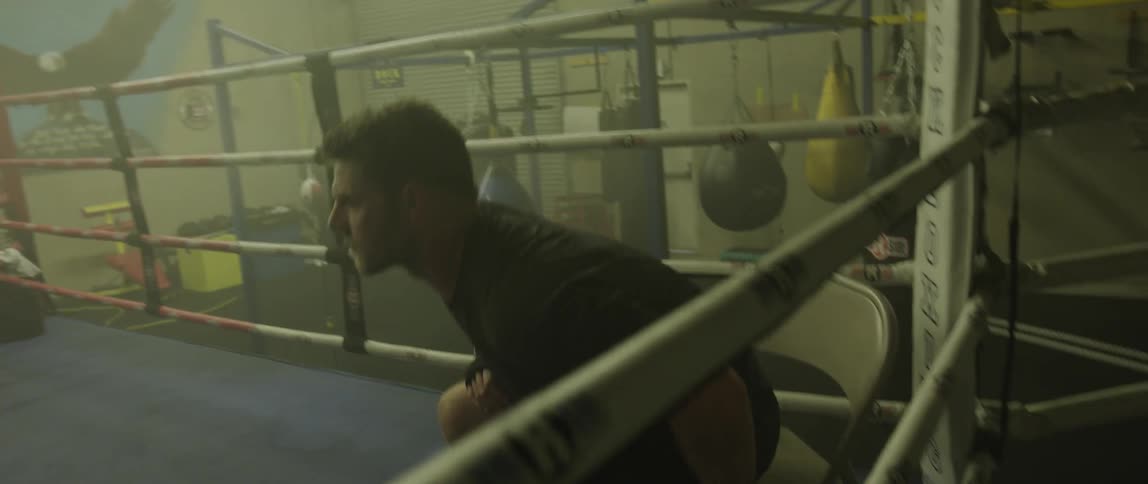 A man sits in a boxing ring