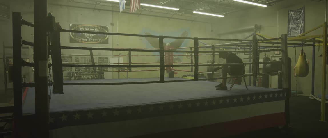 A boxer sits in the corner of a ring