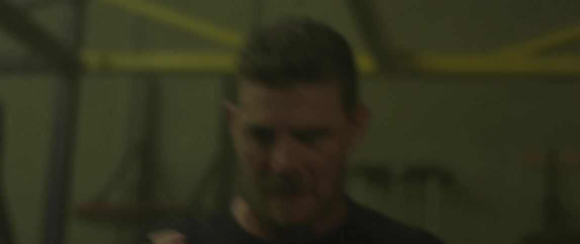 A man hits a punching bag with his fists in a gym