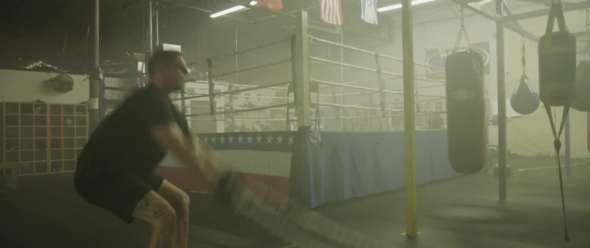 A man swings ropes at a gym