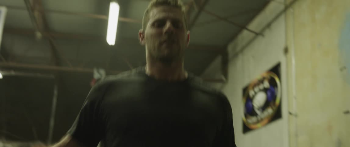 A white man jumps rope in a gym