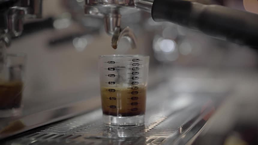 Coffee drips from a professional stainless steel coffee maker
