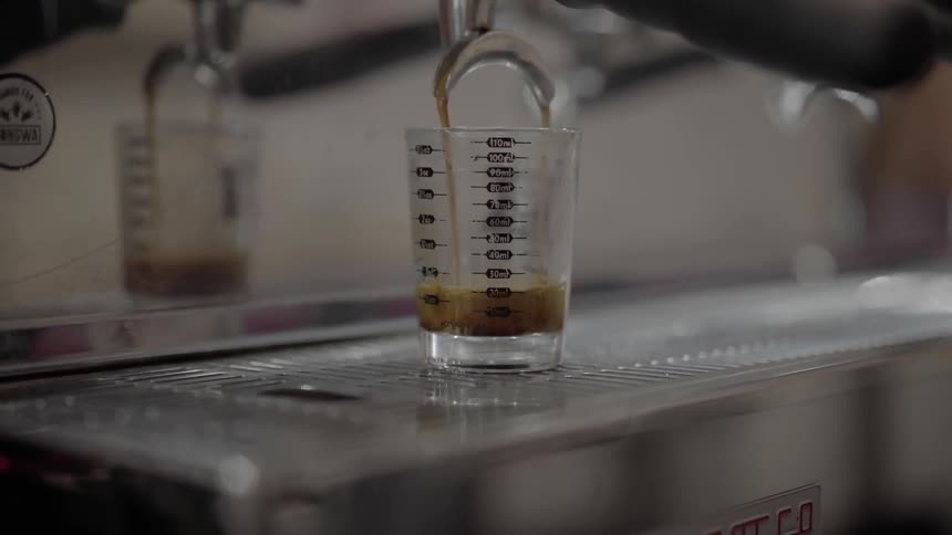 Liquid is being poured into a glass in a kitchen