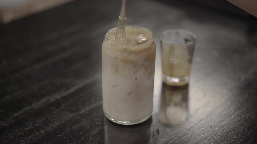 Iced coffee being mixed with a whisk