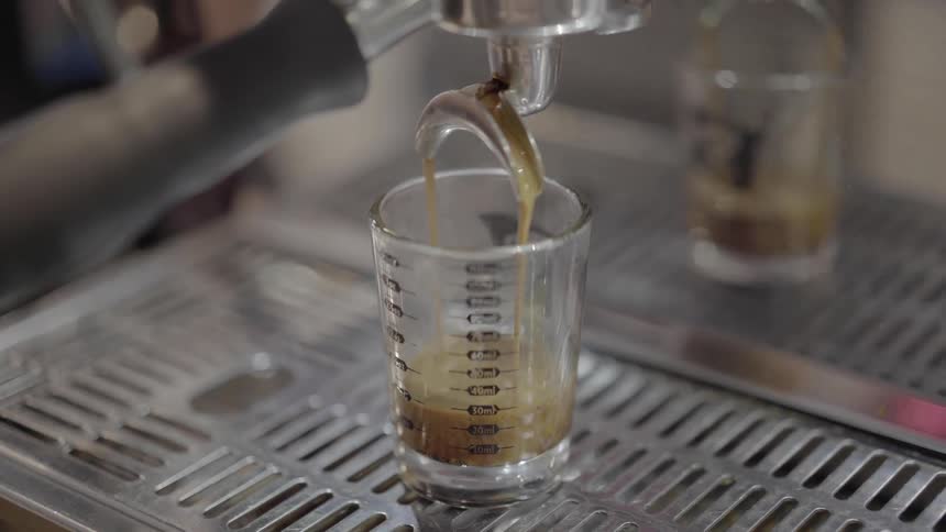 A coffee machine pours a shot