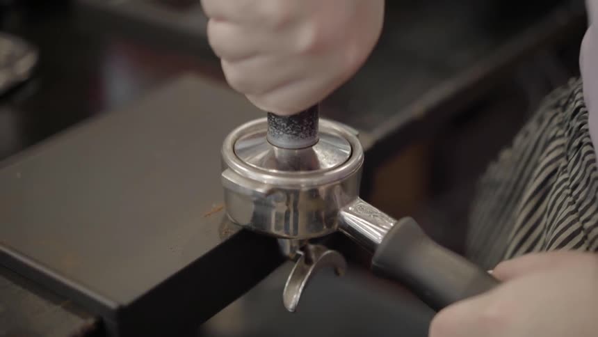 Woman presses the coffee in the coffee press
