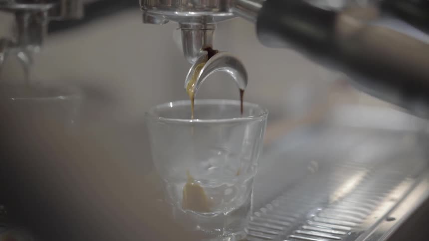 Alcohol drips into shot glass on bar