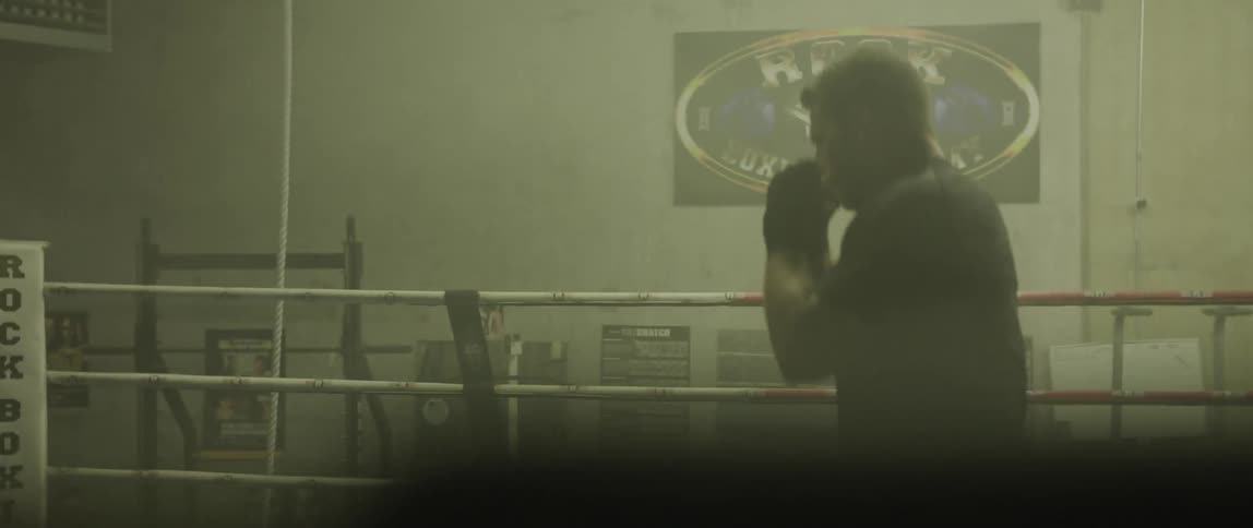 A man throws punches in a boxing ring