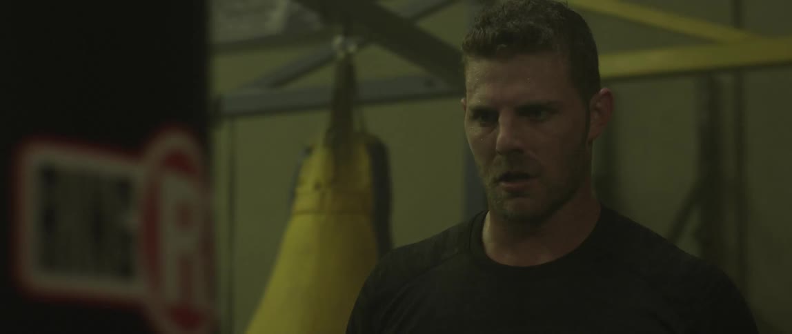 A man looks intently at a punching bag