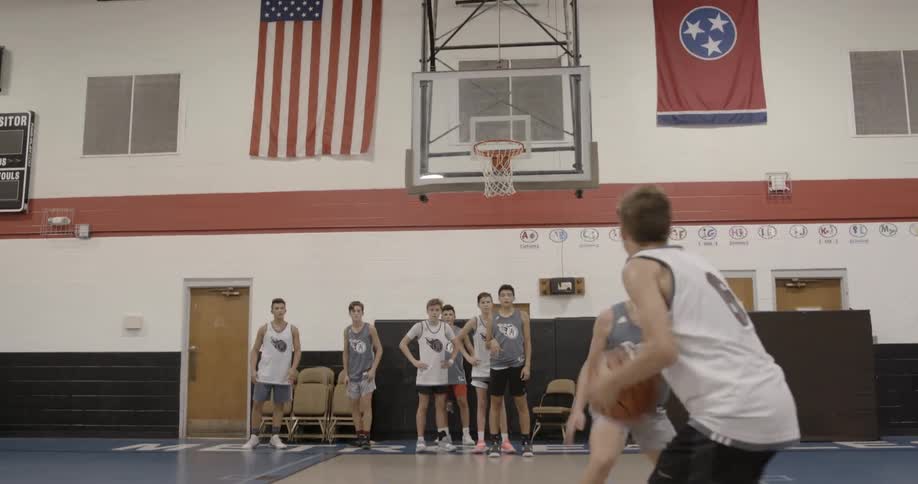 A group of teens playing basketball in a gym