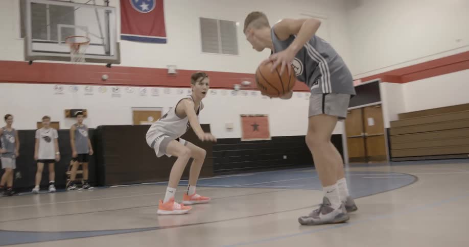 Men play basketball on court