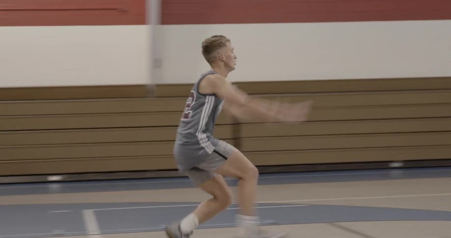 Teenage boys playing basketball in gymnasium