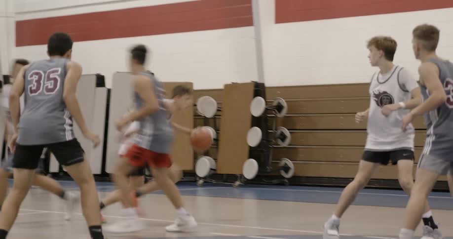 Many teen boys are on the basketball court