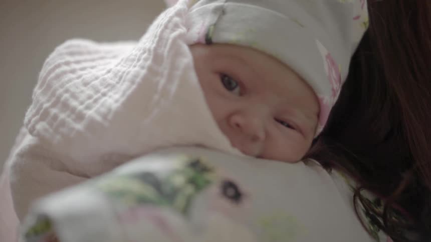 A woman holding a baby on her shoulders