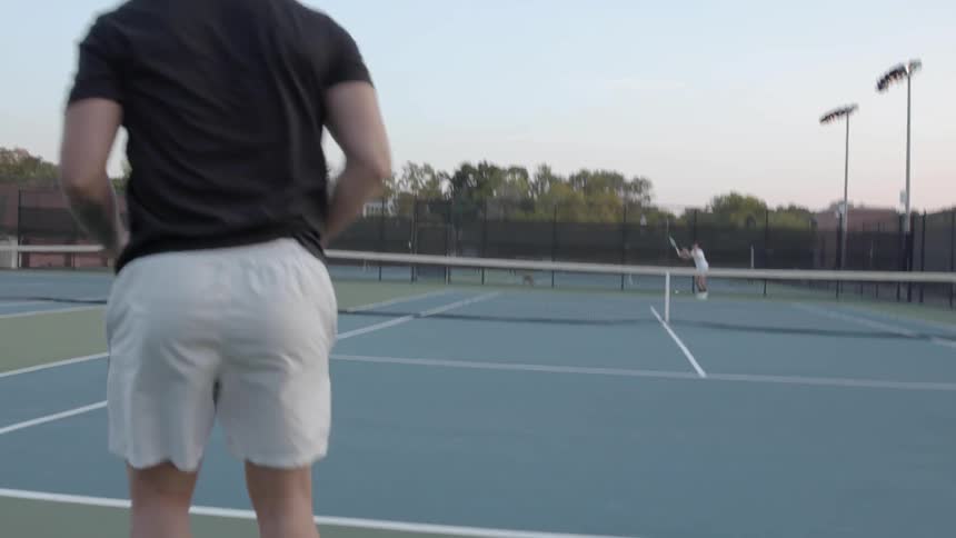Two people are hitting the ball around on the tennis court