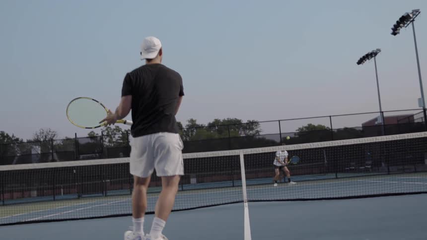 Two men playing tennis outside