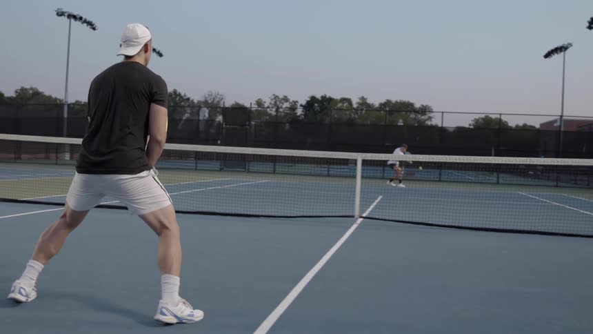 Two men playing tennis on a court