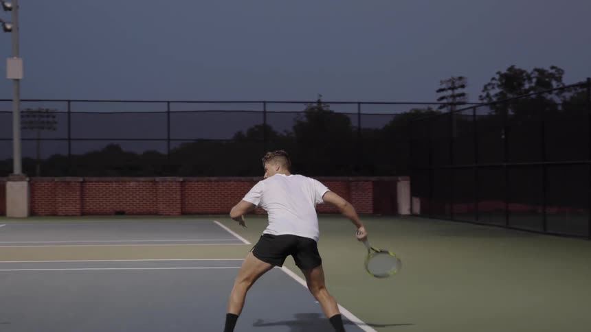 A man hits a tennis ball with a racquet