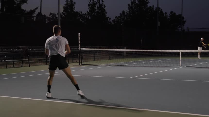 Two men play tennis together