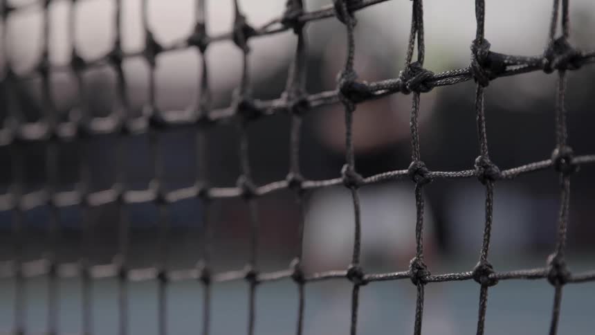 A man volleying a tennis ball over a net