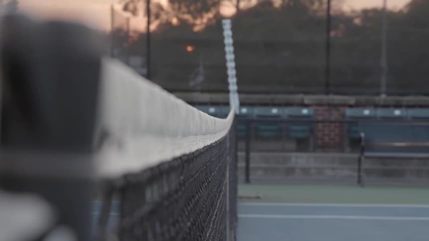 A tennis ball is served over the net