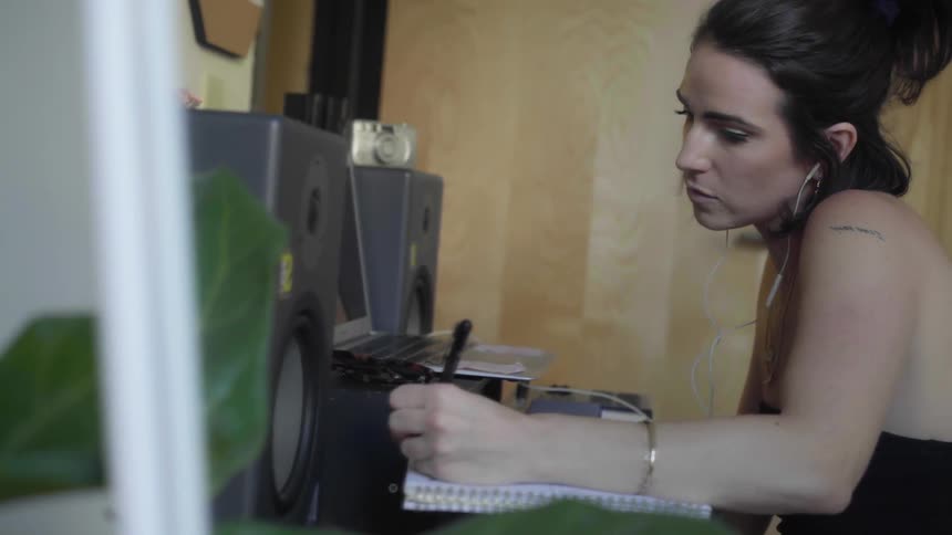 A woman is writing at the desk
