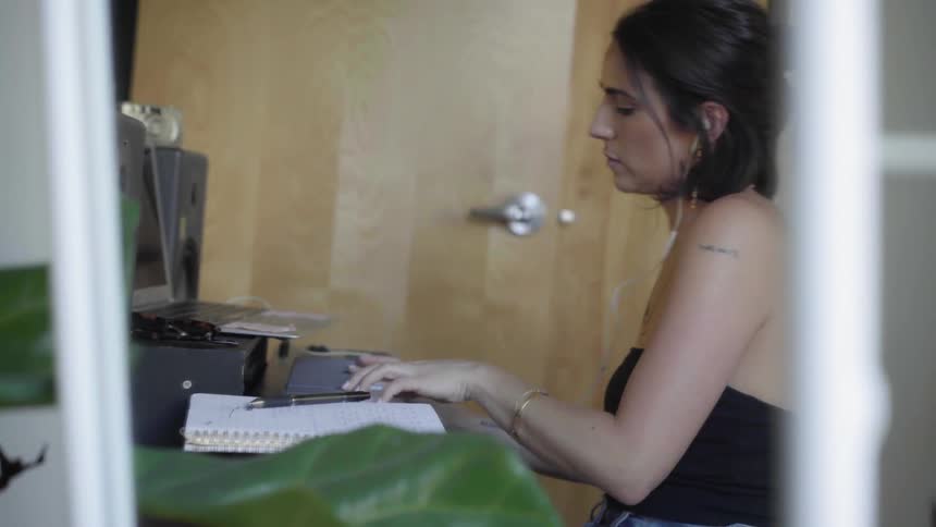 A woman dances to music while she plays on a keyboard