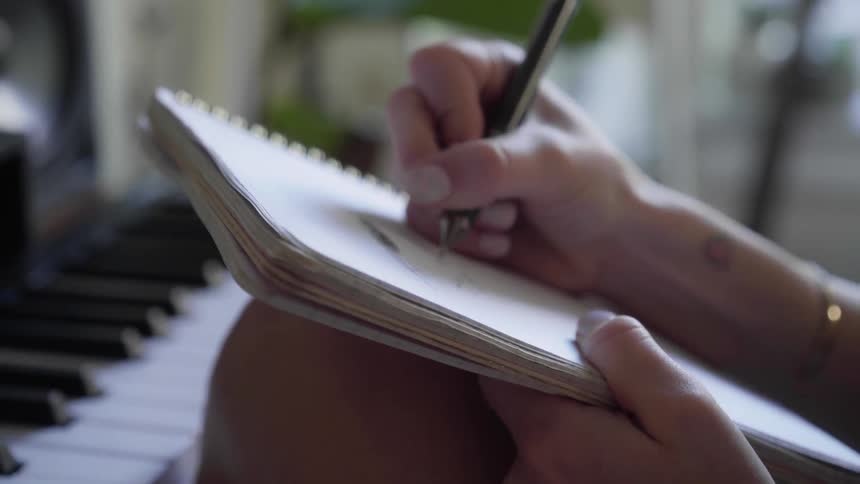 A person is writing in a notebook