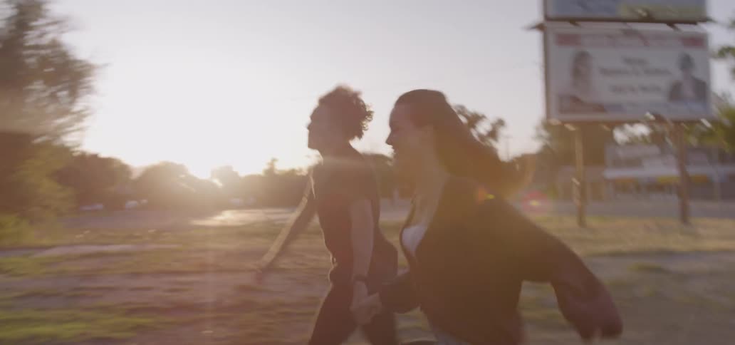 Young couple running together from a car towards a building