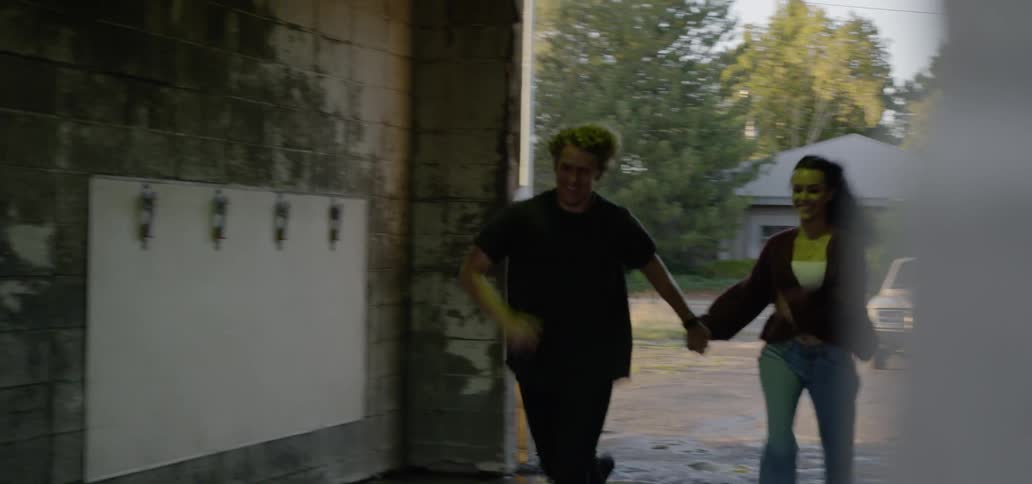 A man and woman running into a car wash garage