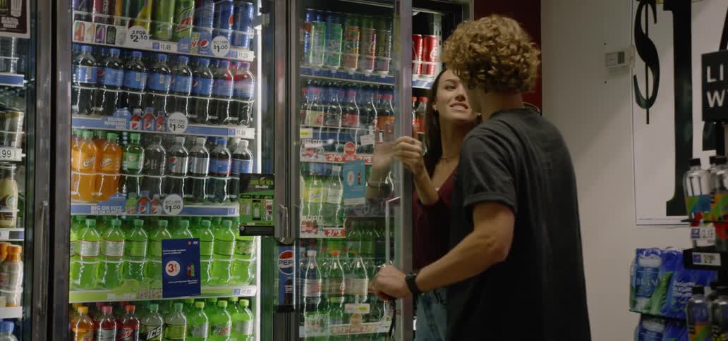 Two people are grabbing soda at the store