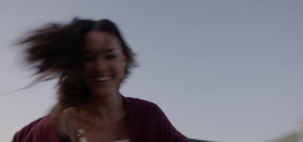 A man and a woman spin around together in a parking lot