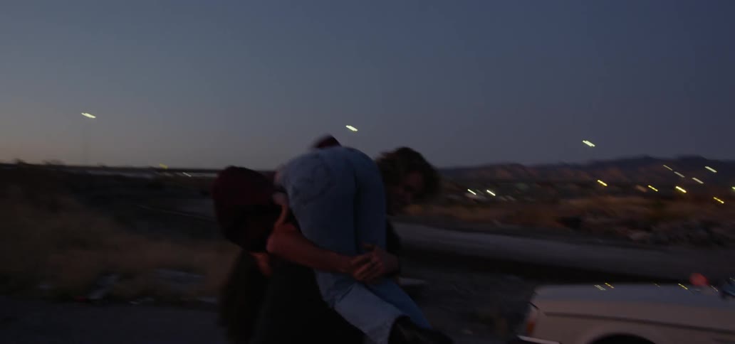 Man playfully spins a young woman over his shoulder