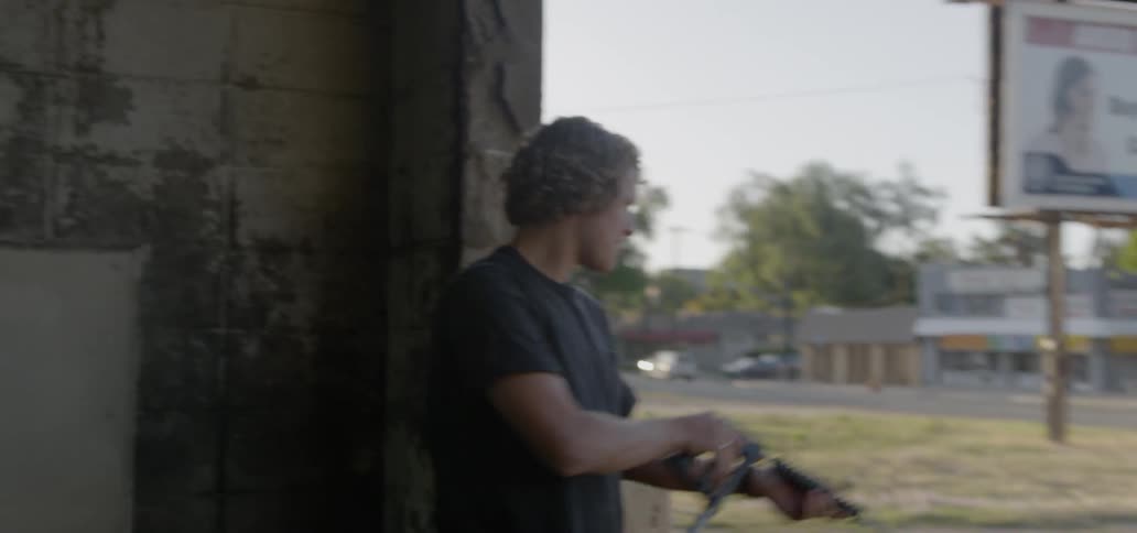 Young man washes his vintage car with a spray hose