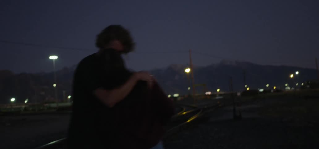 A couple kisses and then runs off together at night