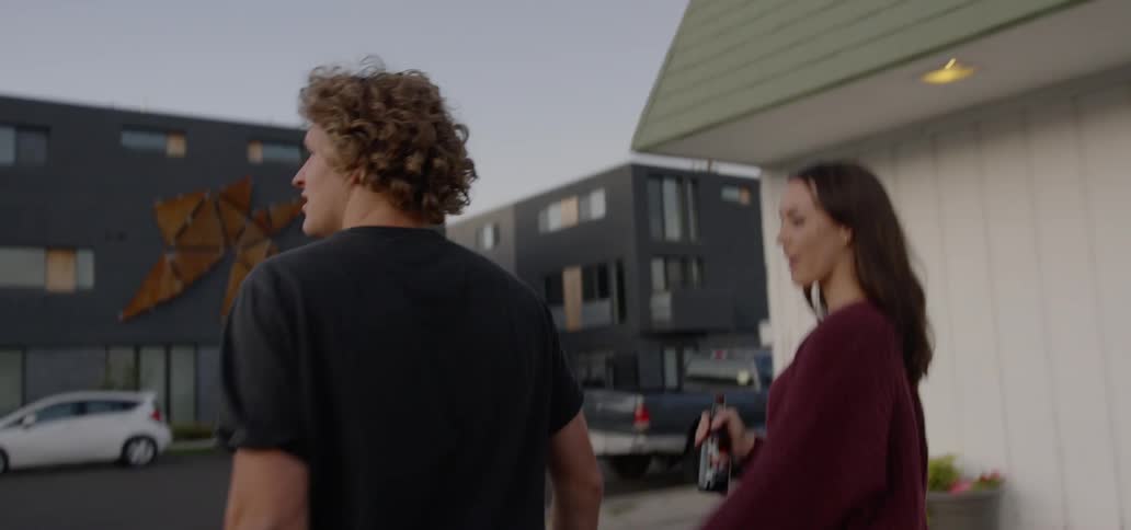 Woman and man walk and hold hands at dusk