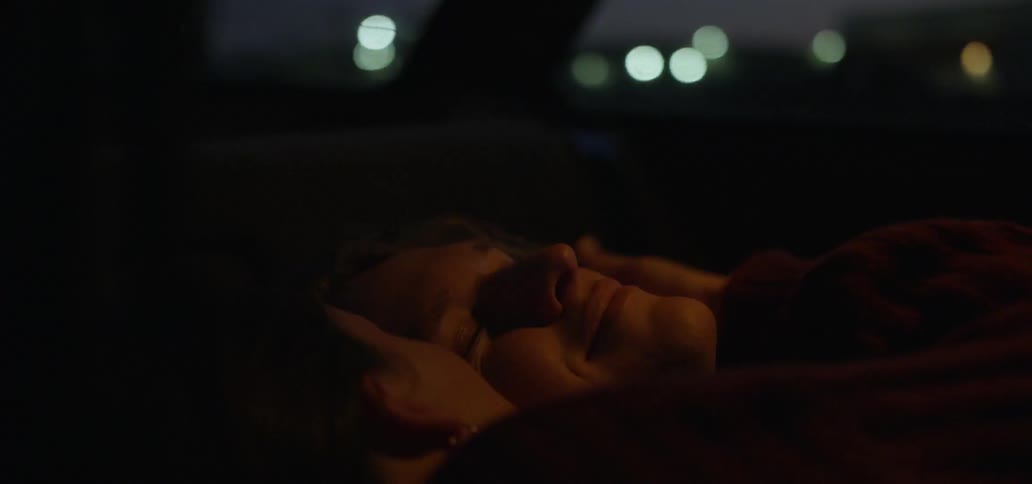 Couple lying inside car kissing and looking at the stars