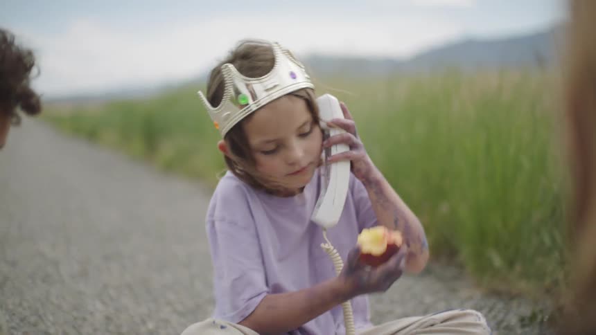 A girl talks on an old phone