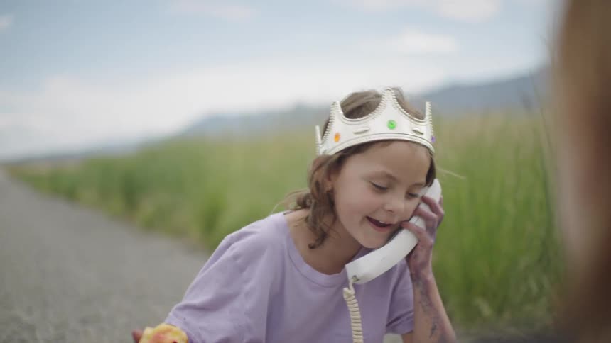 Young girl eating an apple and talking on a phone