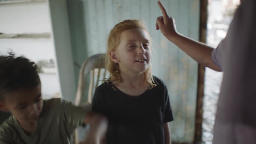 Woman plays a trick on kids by touching their faces