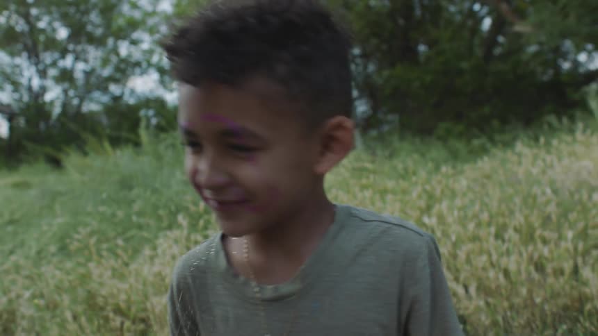 Two children playing in a field with sparkles