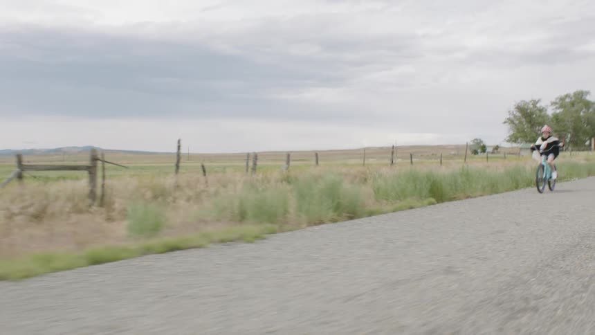 A child rides a bike on a rural road