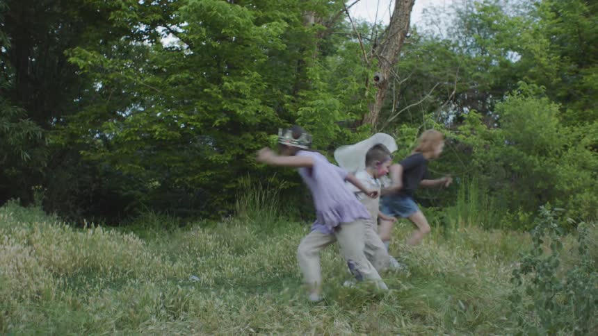 Four kids run and play in a field