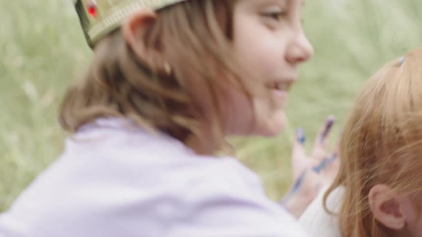 Children excitedly paint outdoors