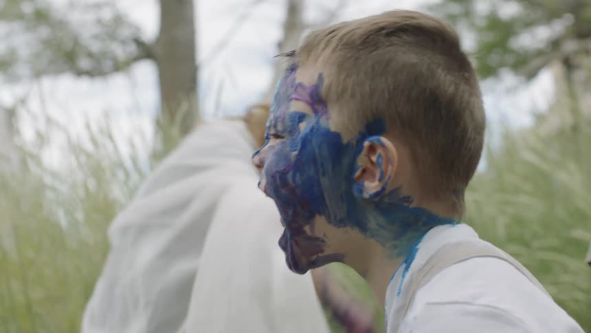Children covering themselves with paint and yelling