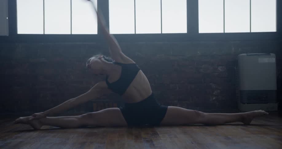A woman stretches while doing the splits