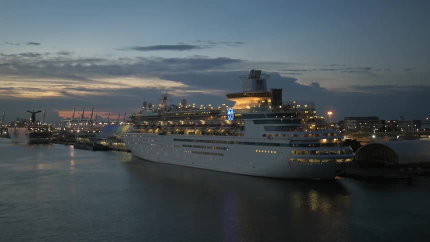 Cruise ship leaving a port at sunset