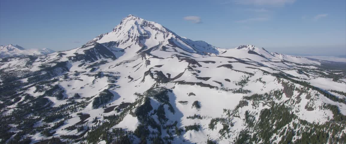 A snow covered forest and mountain range