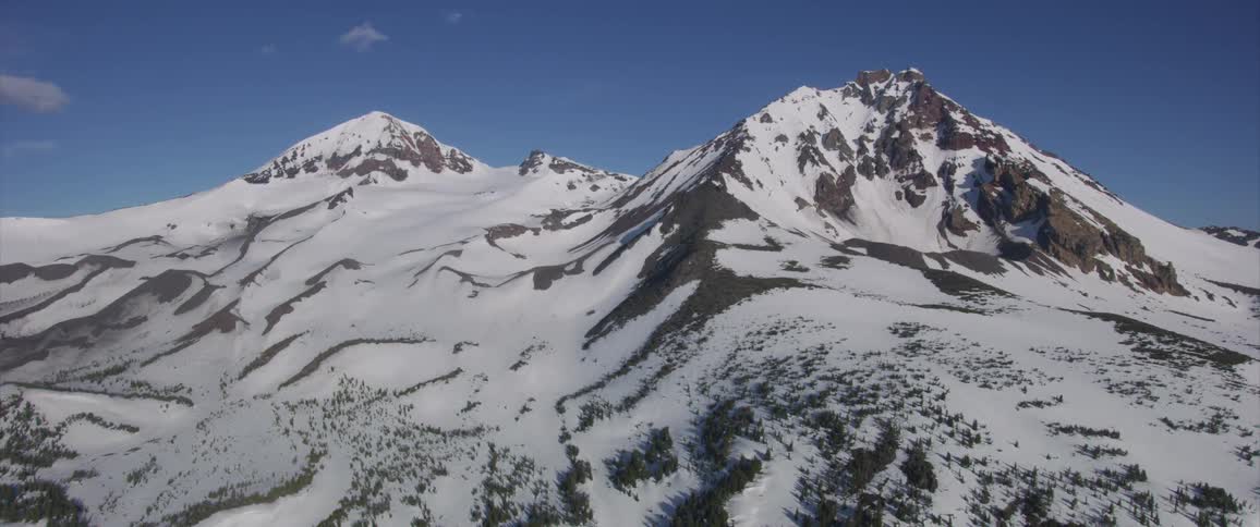 Aerial view of snow capped mountains on a clear sunny day